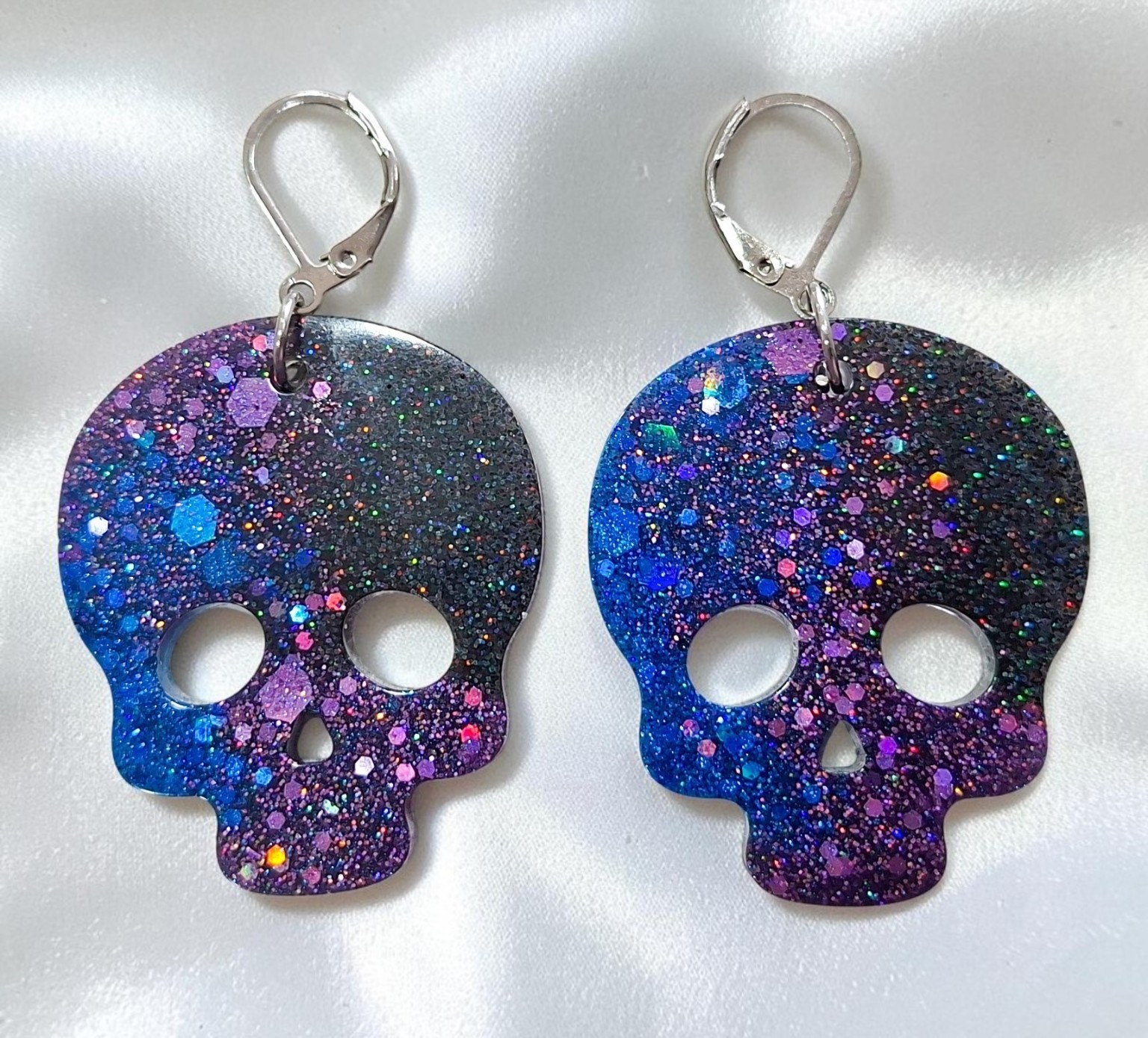 Große Totenkopf-Ohrringe aus Epoxidharz in Blau, Lila und Schwarz mit holografischem Glitzer